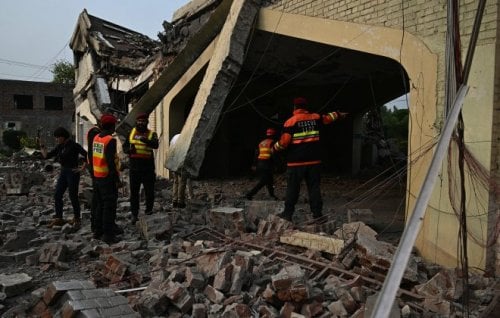 Rescue workers inspect damage caused by Indian air strikes to a building.